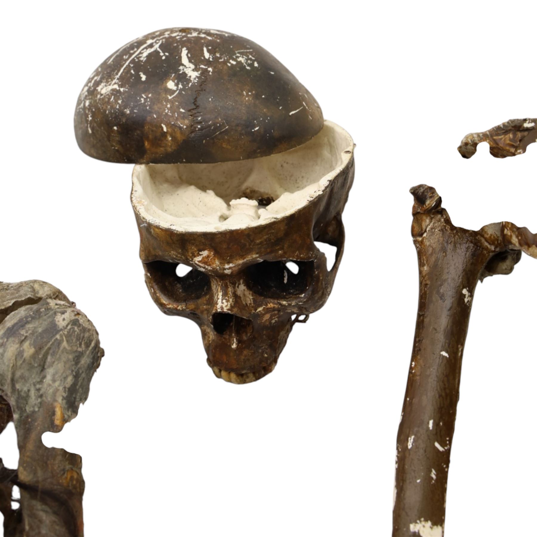 FILM PROPS; four decomposing prop cadavers, each with articulated joints and limbs, likely from a TV or film production, each prop displays intricate detailing with realistic aging and weathering, with a body bag