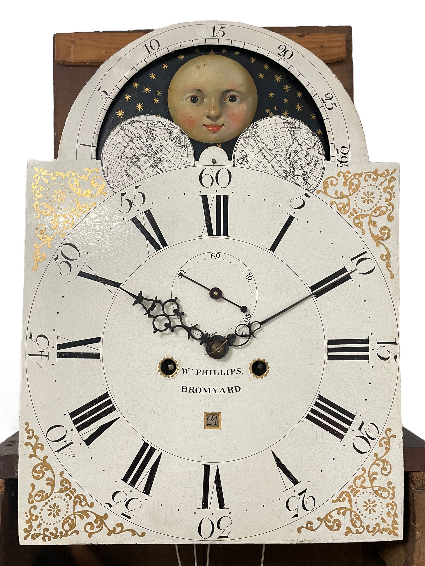 W. Phillips of Bromyard - 8-day mahogany longcase with a painted moon roller dial, c 1790,
swans neck pediment with dog tooth moulding, raised carving and  brass paterie, break arch hood door beneath flanked by reeded pilasters with brass Corinthian capitals, trunk with a blind fret, reeded quarter columns and long wavy topped door,
Plinth with a deep moulding and canted corners raised on a shaped base, painted dial with gesso spandrels, Roman numerals, five minute Arabic's and minute dots, with steel hands, seconds dial and square date aperture, dial pinned to a rack striking movement with an anchor escapement, striking the hours on a cast bell. A clockmaker by the name of John Phillips is recorded as working in Bromyard (Worcs)  in the early to mid 18th century, certainly by 1770-90. W. Phillips was possibly an unrecorded son or brother also working in the same family clockmaking business during the later part of the 18th century.
