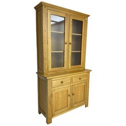 Contemporary light oak bookcase display cabinet, fitted with  two glazed doors enclosing two shelves, above two drawers and cupboards