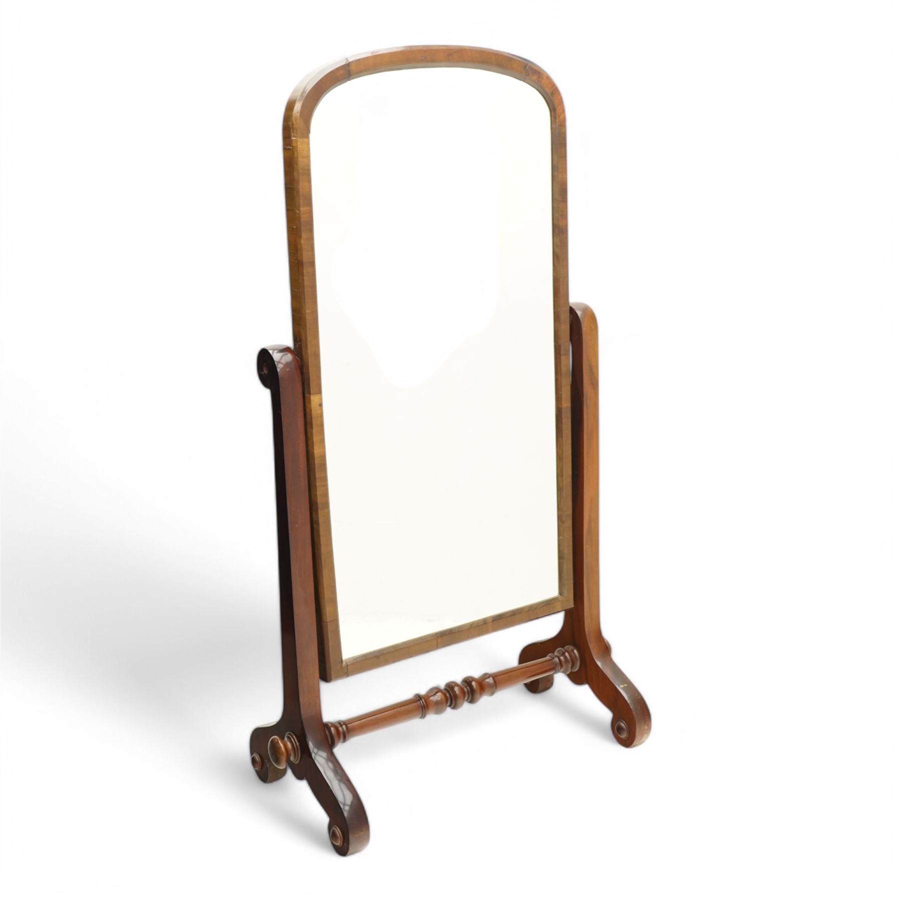 Early 19th century mahogany cheval dressing mirror, plain mirror plate within chamfered frame with arched top, on rolled horns and out-splayed rolled feet, united by turned stretcher 