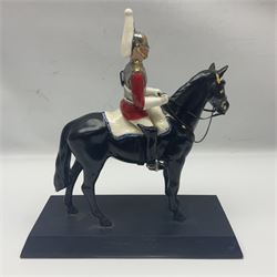 Mounted Lifeguard upon a black horse, in the style of Beswick, upon a wooden plinth, H31cm