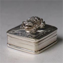 Modern silver pill box, of square form, the hinged cover surmounted with figure of a frog ...