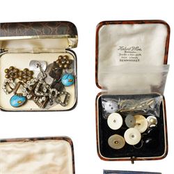 Early 20th century dress sets including onyx and paste examples, some stamped 935, paste set buckles and buttons, faux turquoise jabot pin, in the style of Bernard Instone, silver cufflinks etc, housed in an early 20th century red leather jewellery box