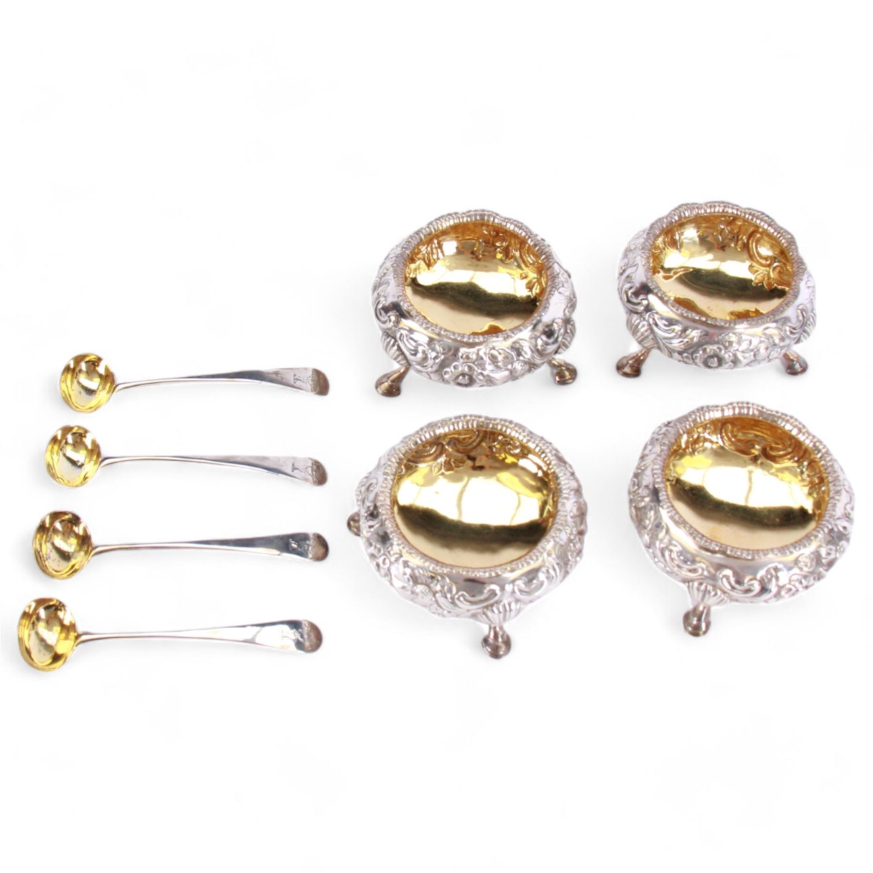 Cased set of four Victorian silver open salts, each of cauldron form with embossed foliate decoration, gadrooned rim and gilt interior, upon three hoof feet, hallmarked William Hunter, London 1844, H4cm, together with four earlier Georgian salt spoons, hallmarked London 1800, makers marks worn and indistinct, contained within a fitted case with velvet and silk lined interior
