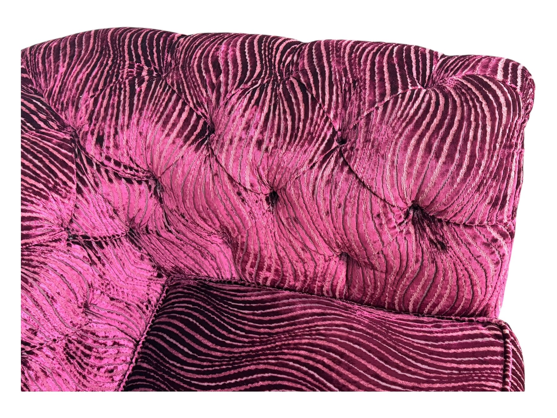 Contemporary Chesterfield design two-seat sofa, upholstered in fuchsia crushed velvet with a ribbed and tufted design, the rolled arms and deep-buttoned backrest raised on square block supports