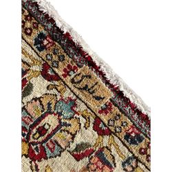Persian Tabriz crimson ground rug, the field decorated with large palmette and stylised plant motifs connected by interlaced leafy branches, trailing border decorated with similar palmette motifs within floral pattern guard stripes, with signature panel 