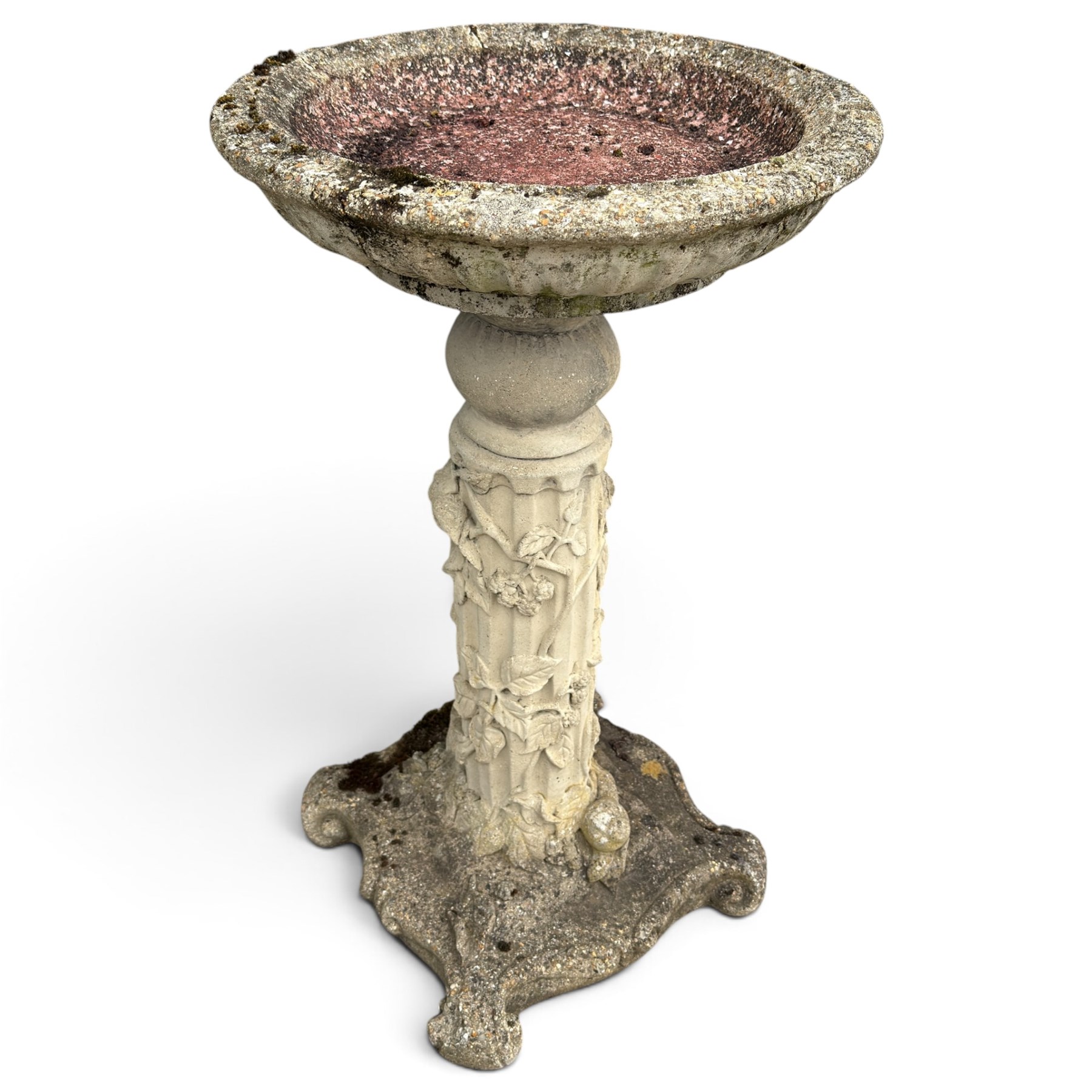 Weathered cast stone birdbath, the kylix shaped bowl with fluted body, raised on a fruiting foliate vine decorated fluted pedestal with upper knop and bird and fieldmouse motifs, shaped square base with scroll feet