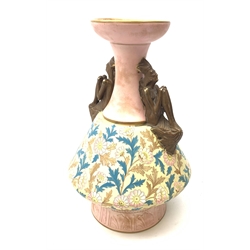 A late 19th century Aesthetic Movement Old Hall vase designed by Christopher Dresser, the flared body decorated with stylised flowering vines, leading to a tapering neck and flared rim with twin figural handles (one s/d), and raised upon a circular footed base, with printed mark beneath, H35cm. 
