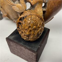 Carved soapstone puzzle ball, together with carved walnut shell and three soapstone brush pots, ball D12cm