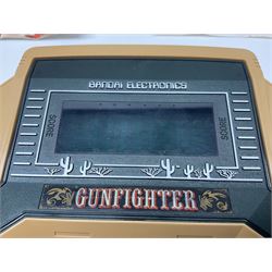 Three late 70s/early 80s handheld electronic games; Bandai Electronics Arcade ‘Gunfighter’ (1980), Grandstand ‘Invader From Space’ (1980), Palitoy ‘Merlin The Electronic Game Machine’ (1979) with game sheet and instruction booklet, all with original boxes (3) 