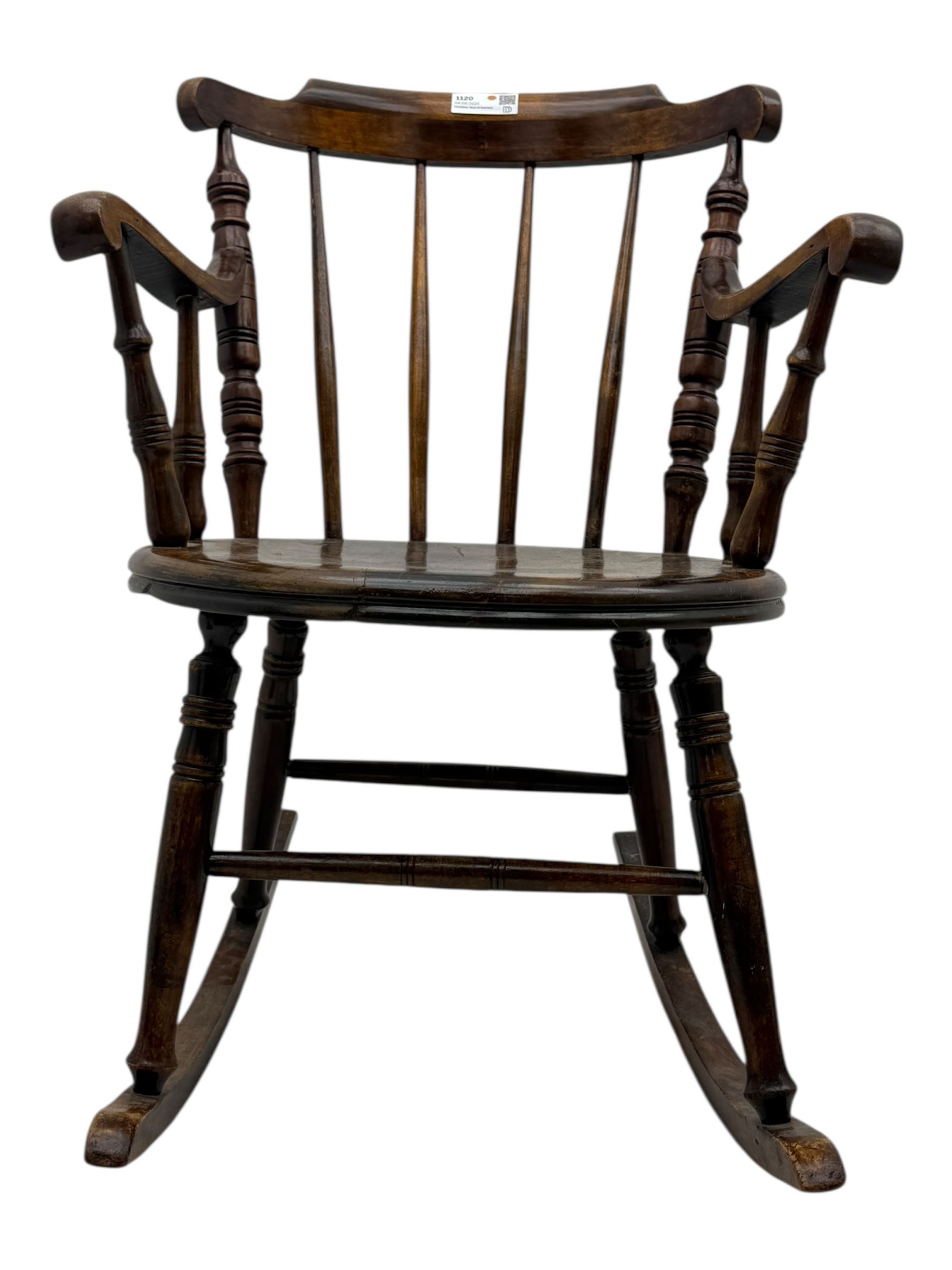Late 19th century elm and beech Windsor rocking chair, with shaped top rail over turned spindles and curved arms, circular seat raised on turned legs united by stretcher on rockers