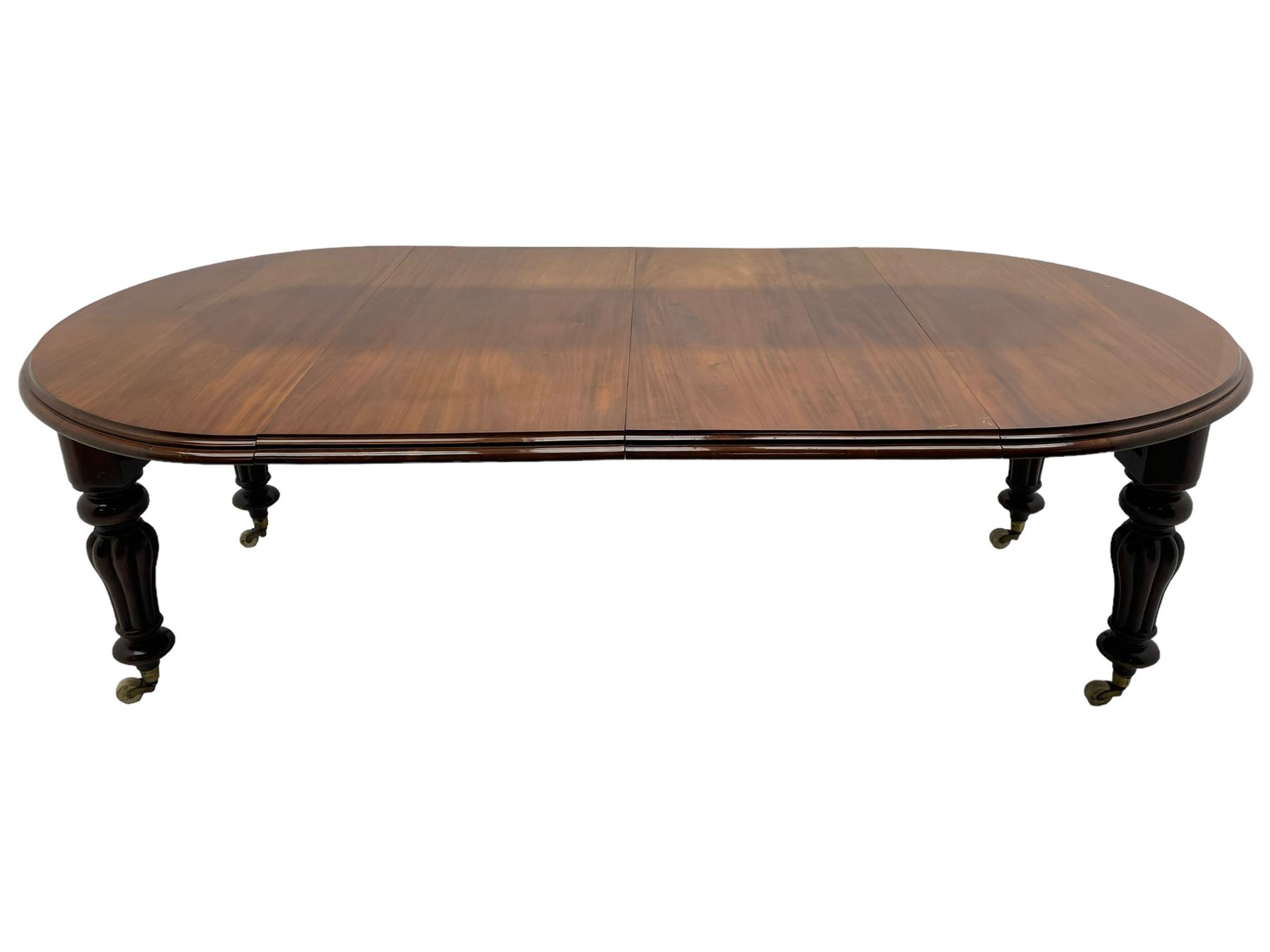 Victorian mahogany extending dining table, circular telescopic extending top with moulded edge, two additional leaves, on turned and lobe carved supports with brass and ceramic castors 