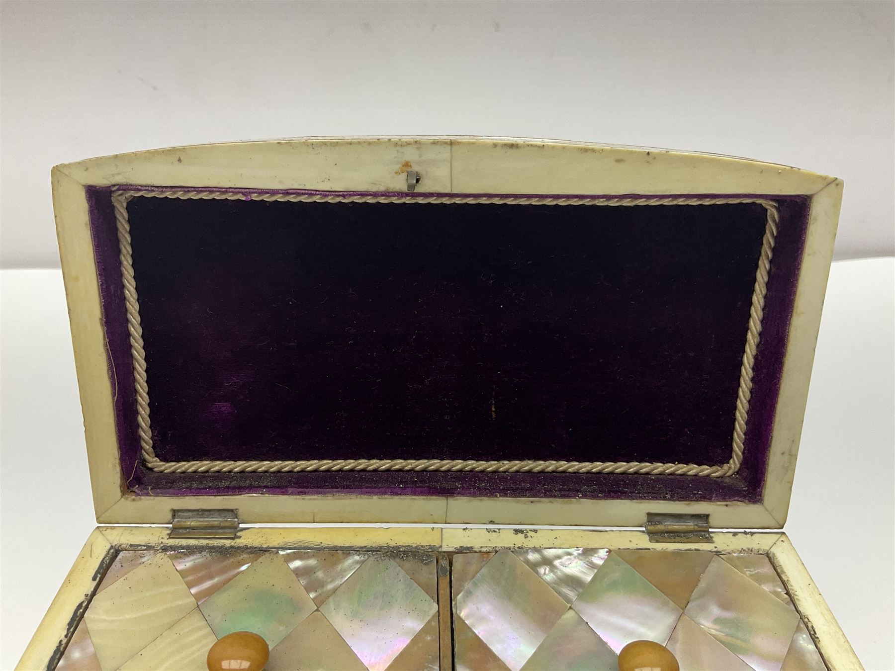Victorian mother of pearl tea caddy, of rectangular bow-fronted form, the body with floral, bird and geometric engraved mother of pearl panels, white metal shield plaque to the cover inscribed with the initials G.J.A and similar escutcheon, the two division interior with ivory edging and two panelled mother of pearl lids, on four vegetable ivory bun feet L20cm, together with a similar style mother of pearl card case (2) This item has been registered for sale under Section 10 of the APHA Ivory Act