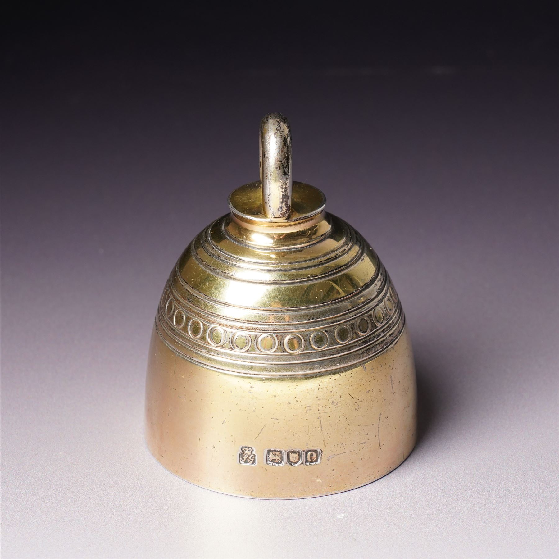 Late Victorian silver gilt table bell with reeded and roundel decoration and loop handle, bell and clapper both hallmarked H7cm London 1900 Maker R & S Garrard & Co