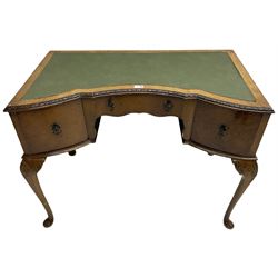 Early 20th century Queen Anne design walnut writing desk, reverse bow-front with inset green leather writing surface and foliate carved edge, fitted with three drawers, raised on cabriole supports