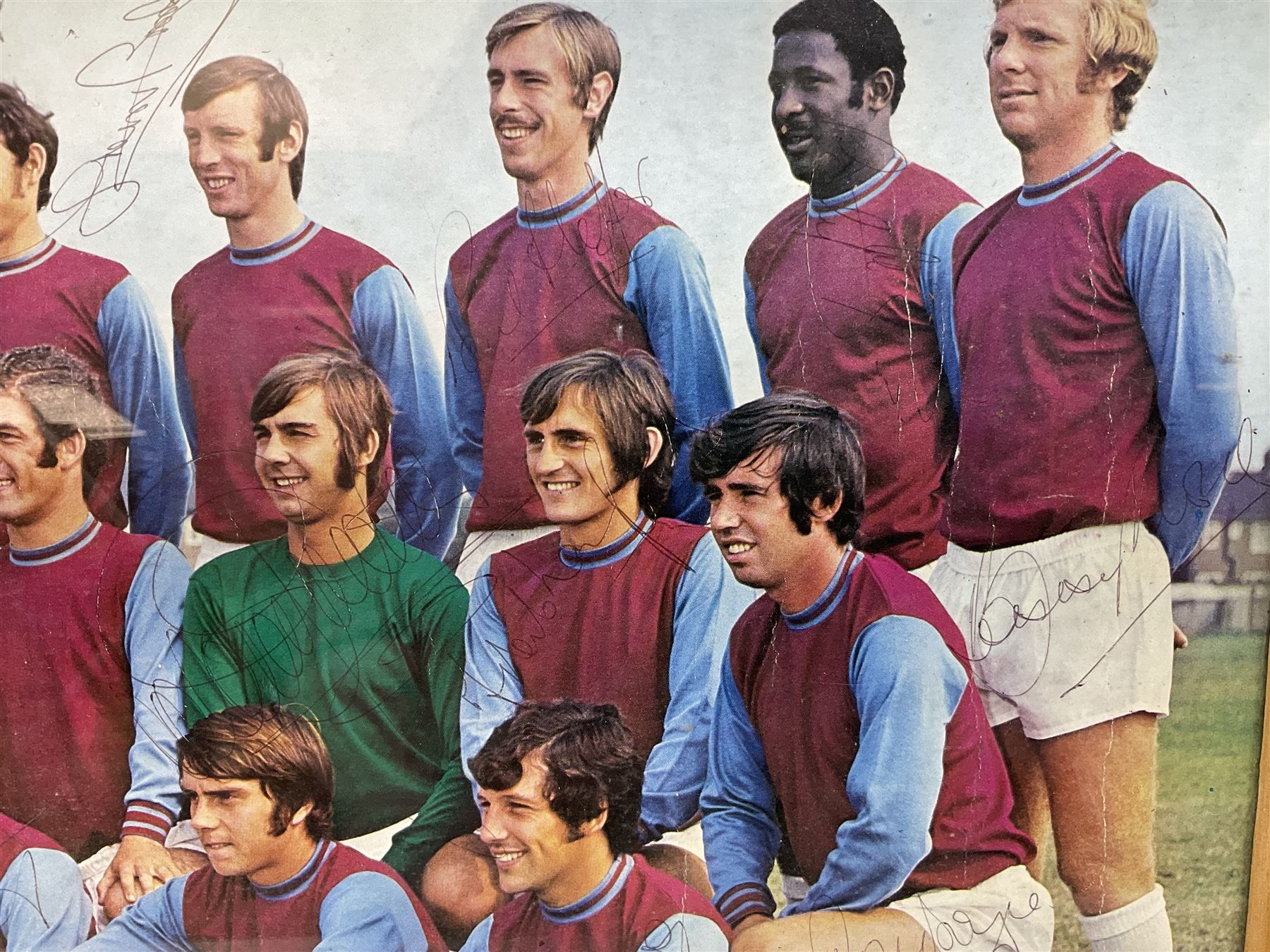 1970-1 photograph of West Ham United FC squad members, including Bobby Moore, Geoff Hurst, Harry Redknapp, Trevor Brooking, Jimmy Greaves, Billy Bonds etc, most players with signatures, 30 x 45cm, framed and glazed