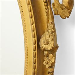 Late 19th century Louis XVI style giltwood and gesso girandole oval wall mirror, the oval frame surmounted with stylized urn finial and ribbon-tied garlands, laurel swags and rosettes, egg and dart decorated inner moulding and linked acorn outer moulding, flanked by intertwined foliate decorated candle branches 