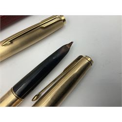 Three rolled gold Parker fountain pens, comprising an example with a gold nib marked 14K 585 and barrel with a shell stamp, a Parker 61 fountain pen with inset gold arrow to the nib, and another similar, all with striated decoration and arrow clips to the caps, L13cm, one with box