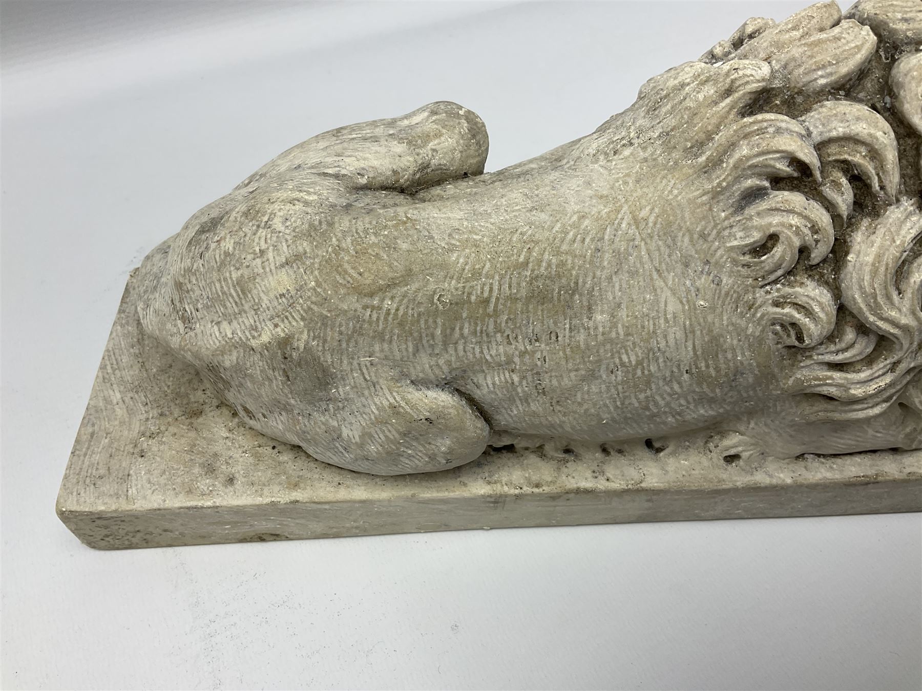 Two early 20th century reconstituted stone Grand Tour or Chatsworth House type lions after Antonio Canova, each modelled in recumbent pose upon a rectangular plinth, signed to plinth Dilettanti, each approximately L31cm