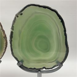 Pair of green agate slices, polished with rough edges raised upon silvered metal stands, H19cm