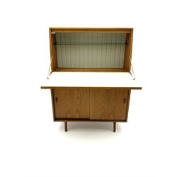 Mid 20th century teak fall front cocktail cabinet, above sliding doors enclosing shelving, raised on shaped supports joined by stretcher