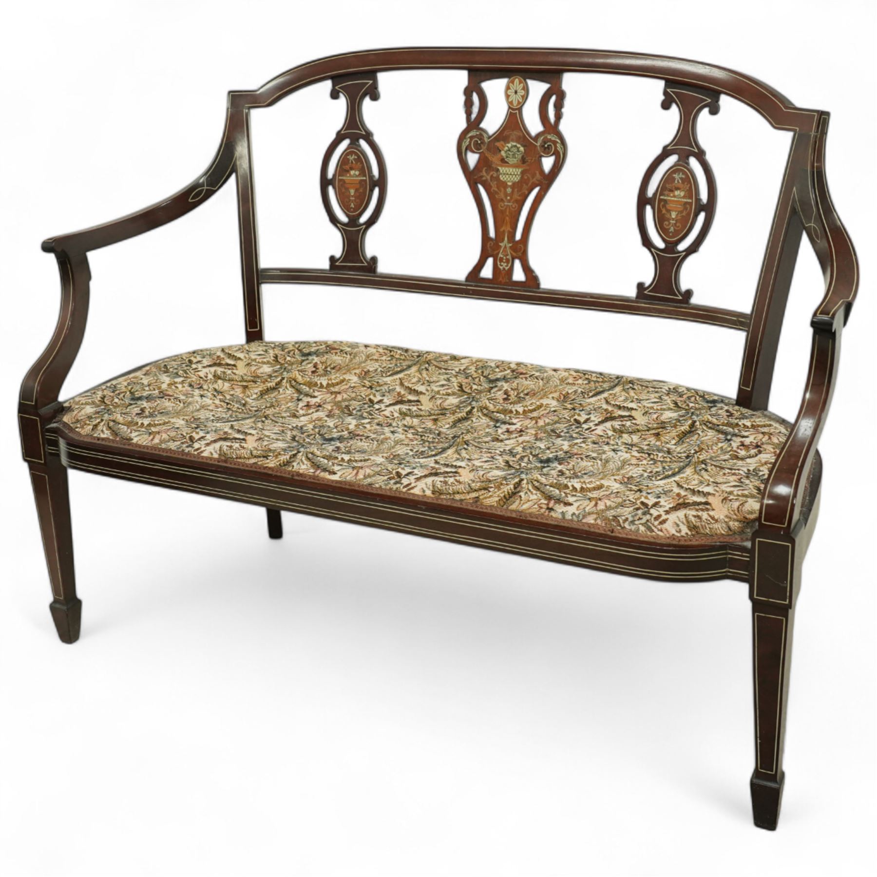 Edwardian marquetry inlaid mahogany salon settee, with bowed top rail and pierced splat back featuring central classical urn flanked by oval floral medallions, floral upholstered seat on boxwood strung square tapering legs terminating in spade feet