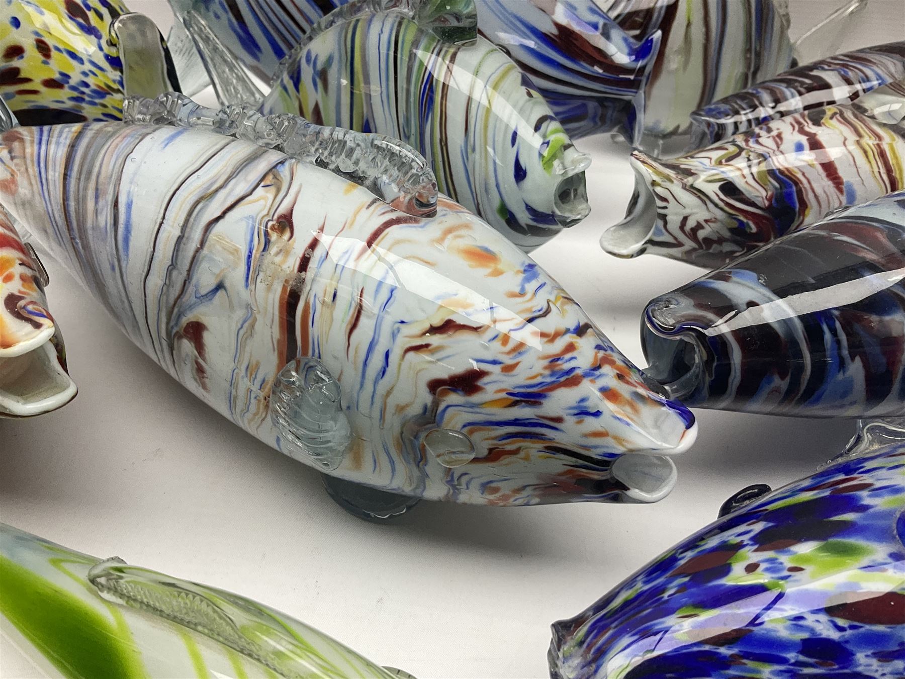 Collection of mid 20th century murano style glass fish, each with multi coloured inclusions largest L42cm