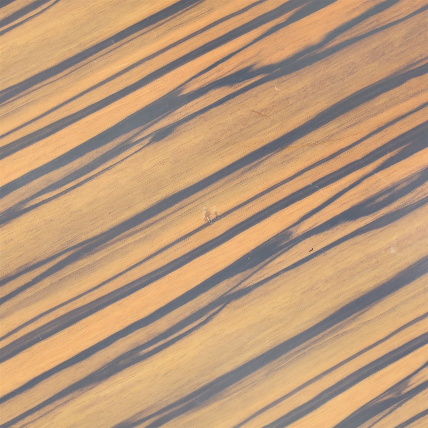 Toby Winteringham - Mid 20th century zebra wood coffee table, oval top with book matched striped veneers over two open tiers painted red, the curved end supports and continuous plinth base veneered to match, recessed plinth base 