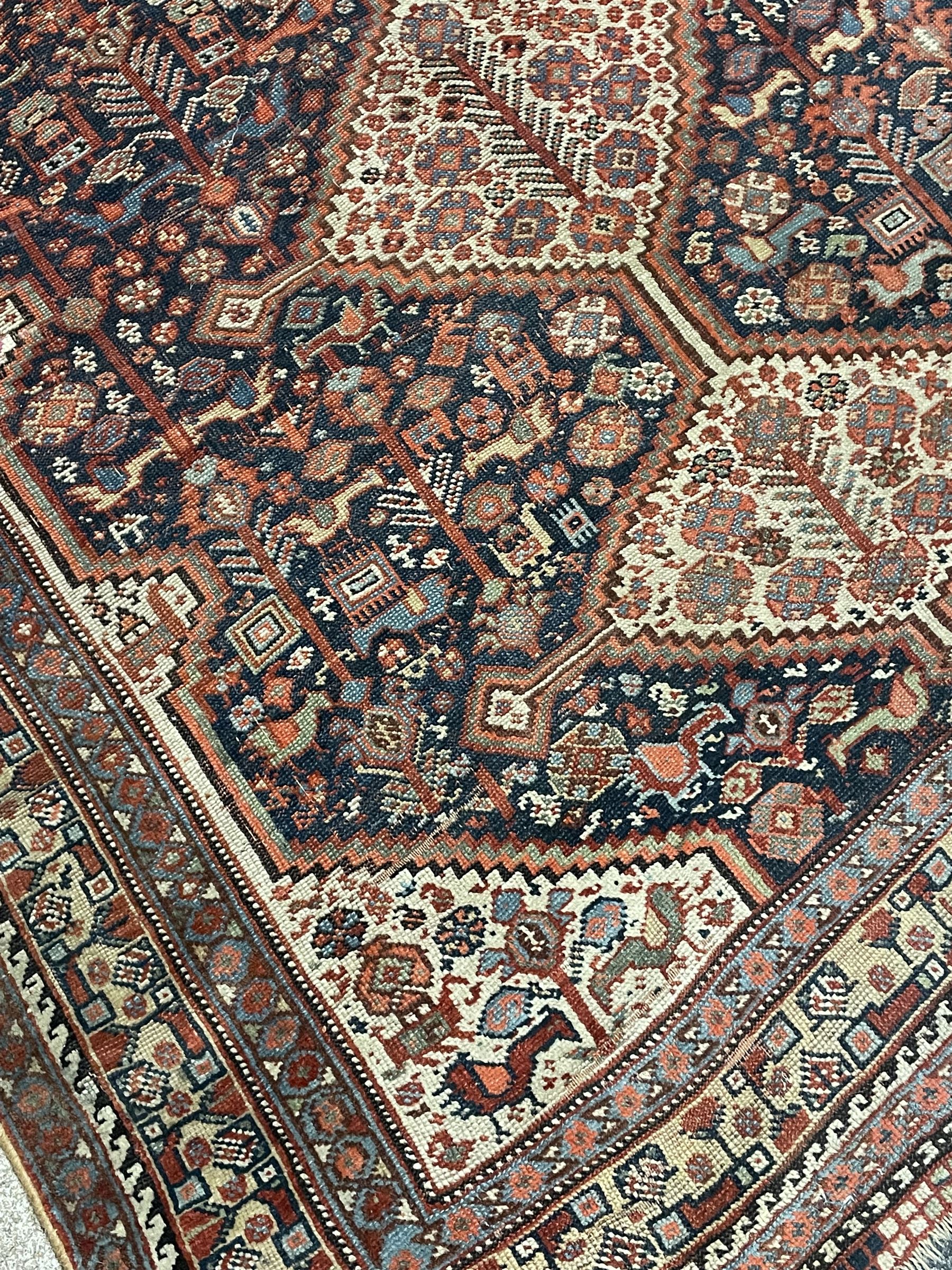 Persian rug, blue ground field decorated with quadruple pole medallion surrounded by animal motifs and stylised flower heads, multiple band border
