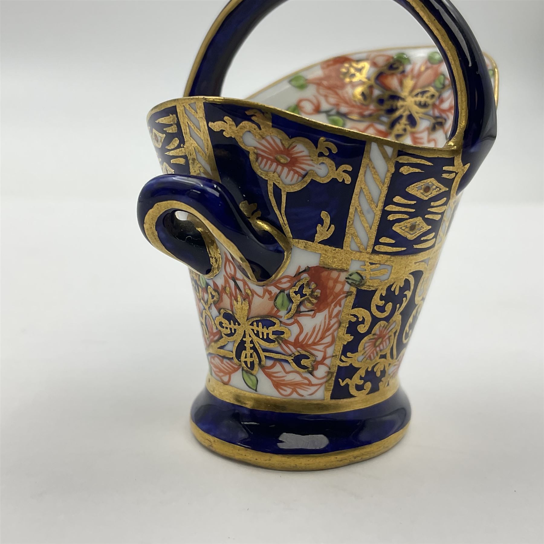 Group of Crown Derby and Royal Crown Derby Imari pattern miniatures, including mid 19th century Stevenson and Hancock cauldron, with painted mark beneath, H5.5cm, a near pair of early Royal Crown Derby scuttles, decorated in the 6299 pattern, each with printed and painted marks beneath including illustration date codes for 1913 and 1922, tallest 6.5cm, and a further early 20th century Royal Crown Derby scuttle, decorated in the 6299 pattern, with printed and painted marks beneath including illustration date code for 1922, H5.5cm, (4)
