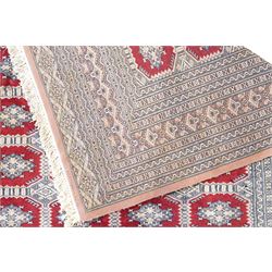 Jaldar Bokhara crimson and pale ground carpet, the field decorated with five rows of Gul motifs, within intricate multi-band border decorated with repeating geometric designs 