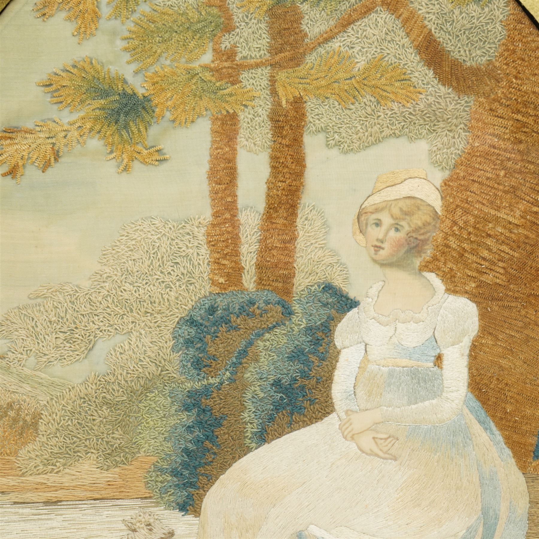 19th century oval woolwork picture of a girl in a garden landscape in verre eglomise frame 45cm x 34cm 