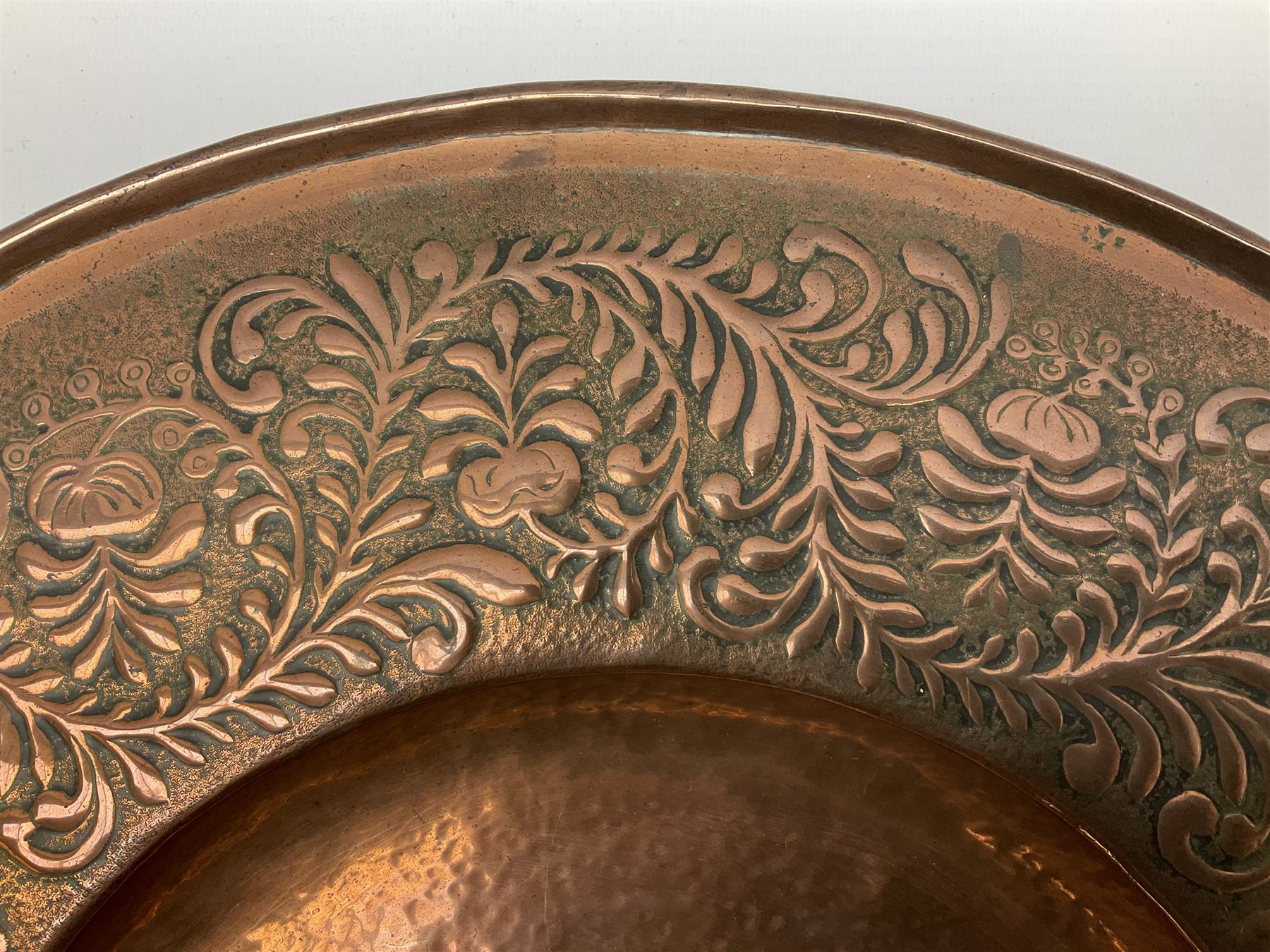 Arts and Crafts Keswick School of Industrial Arts copper charger, decorated with planished centre and repousse scrolling foliate tendrils to rim, D44cm