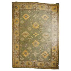 Lage Turkish Oushak green ground carpet, the field decorated with large stylised plant motifs and geometric design, the sage green guard band with further repeating foliate motifs