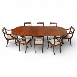 Arthur Brett & Sons - Regency design mahogany extending dining table and eight chairs, the oval top with rounded ends and two extension leaves, raised on twin pedestal supports with swept legs terminating in brass caps and castors, accompanied by a set of eight chairs comprising six single chairs and a pair of carvers, the chairs with curved backs and horizontal splat rails, upholstered seats, sabre legs and scrolling arms to the carvers
(Extends to 252cm)
(Chairs H 86cm, W 52cm)