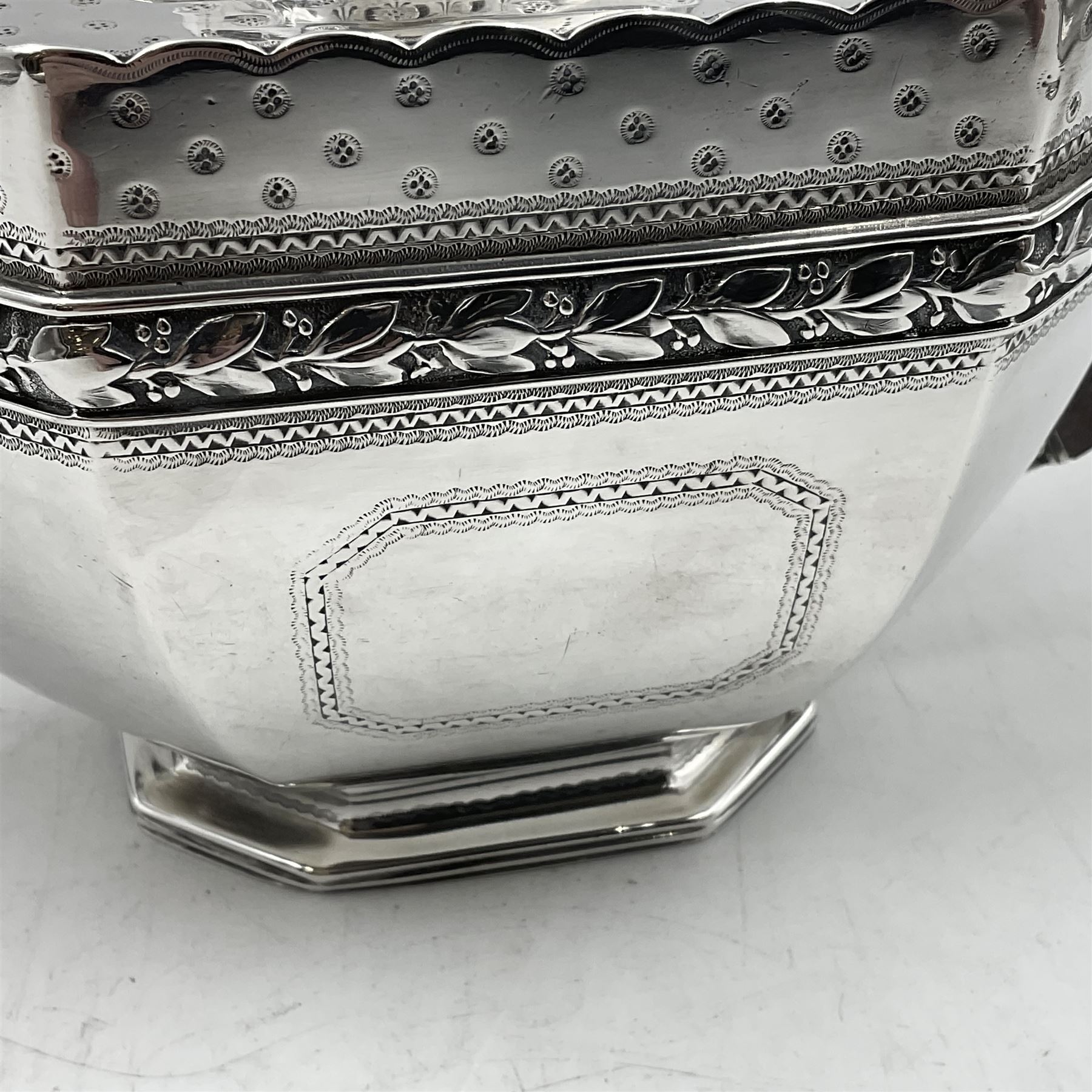 Victorian silver four piece tea service, comprising teapot, teapot stand, twin handled open sucrier and milk jug, each of octagonal form with foliate bud border and engraved decoration including crest to canted panels, and vacant panels, the teapot with ivory finial to the hinged cover and later wooden handle, hallmarked Edward Barnard & Sons Ltd, London1896, teapot including finial H15cm, milk jug including handle H16cm, teapot stand W11.5cm

This item has been registered for sale under Section 10 of the APHA Ivory Act