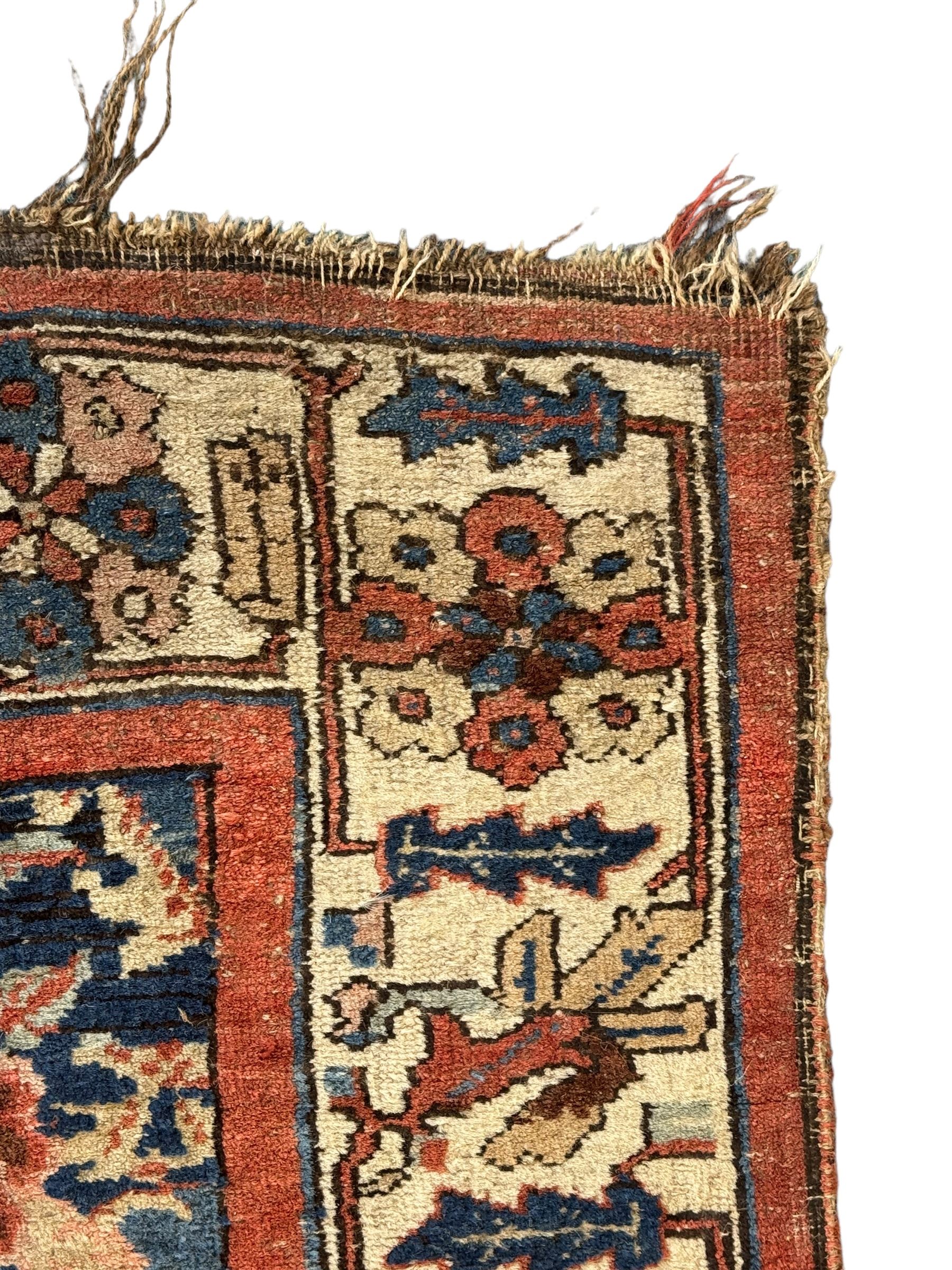Persian Bidjar indigo ground rug, the busy field decorated with large floral motifs, the guarded ivory border adorned with repeating flower heads and stylised leaves
