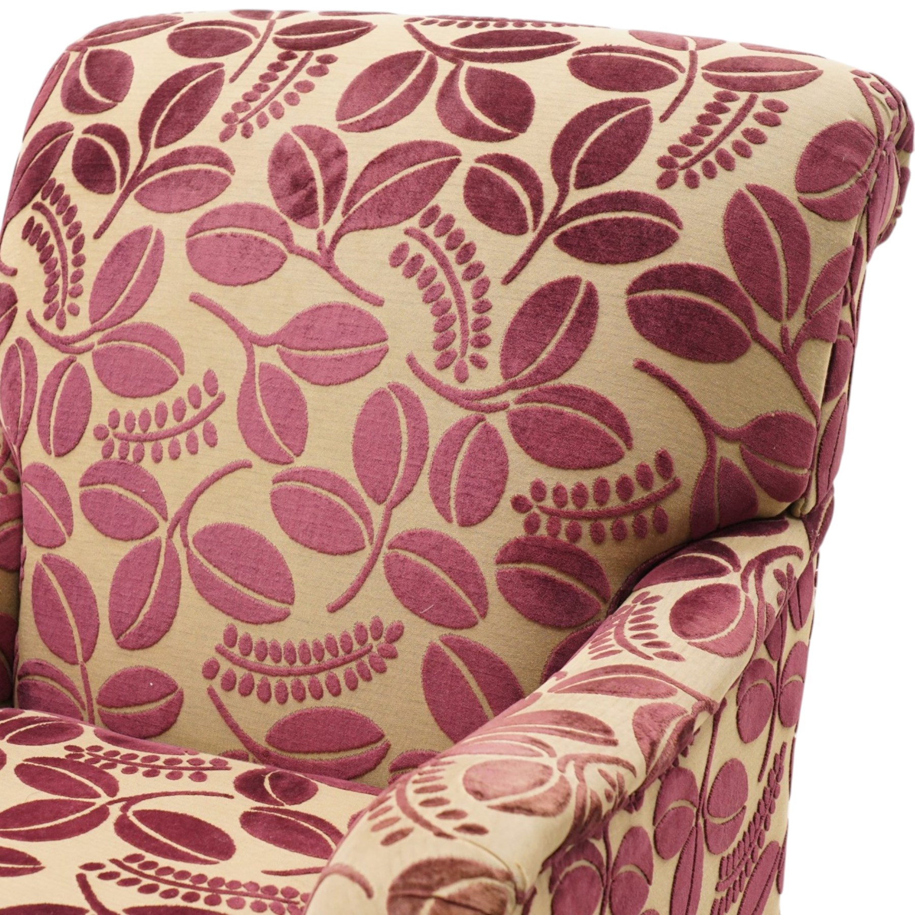 Traditional Howard shape armchair, rolled back and arms over deep seat, raised on turned supports with brass cups and castors, upholstered in plum foliate patterned fabric with loose seat cushion