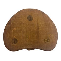 'Mouseman' oak three-legged stool, kidney shaped dished seat carved with mouse signature to edge, by Robert Thomas of Kilburn