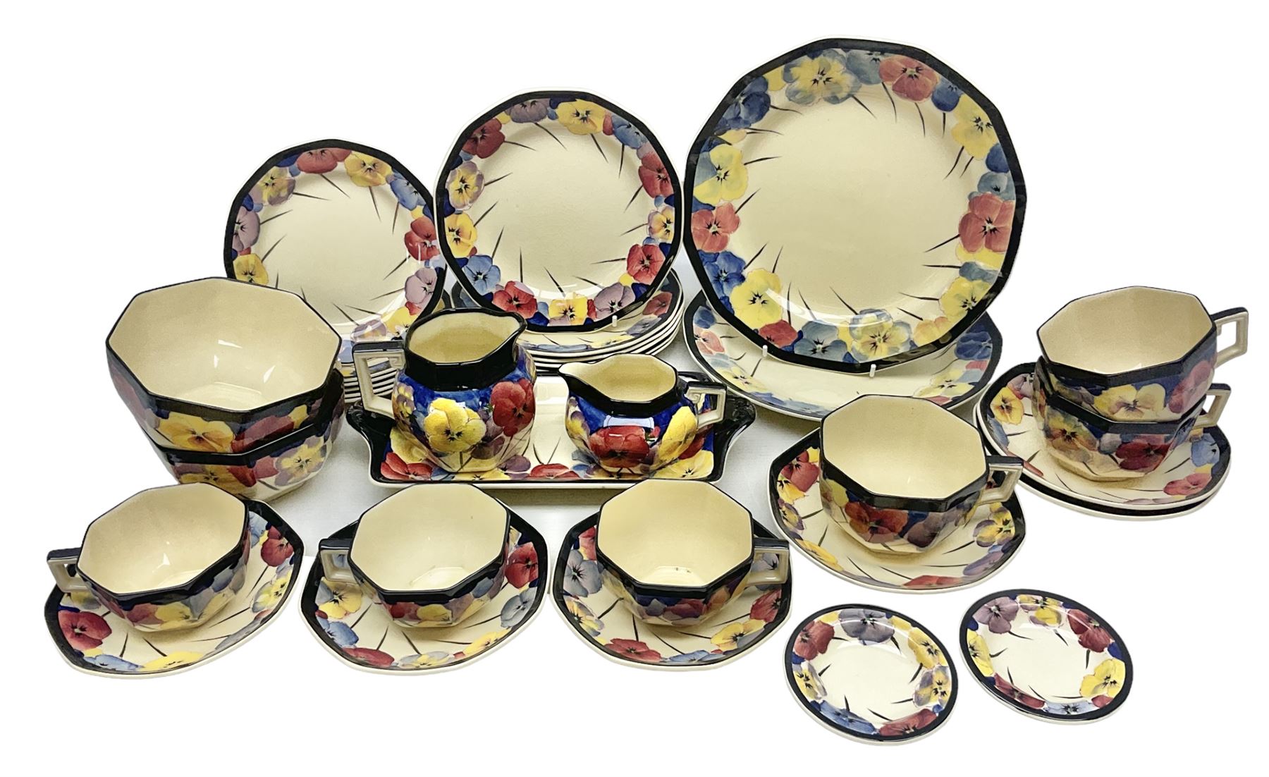 Early 20th century Art Deco Royal Doulton Pansies pattern octagonal teawares, comprising three larger teacups and saucers, three smaller teacups and saucers, open sucrier, two jugs, slop bowl, six side plates, two larger plates, two small circular dishes and one long twin handled rectangular dish, all with printed marks beneath, Rd No 597783, pattern no D4049