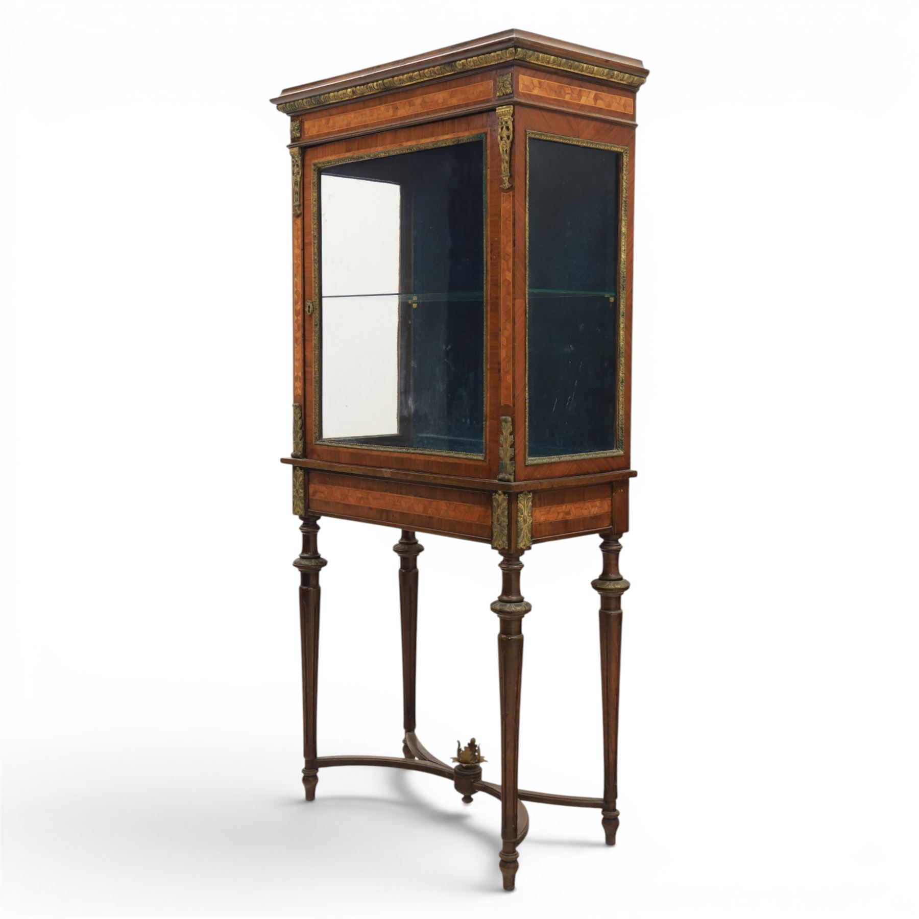French kingwood display vitrine, rectangular glazed case with baized lined interior, parquetry banding and gilt metal bead mounts, applied gilt metal foliate corner mounts, raised on turned supports united by shaped undertier stretchers