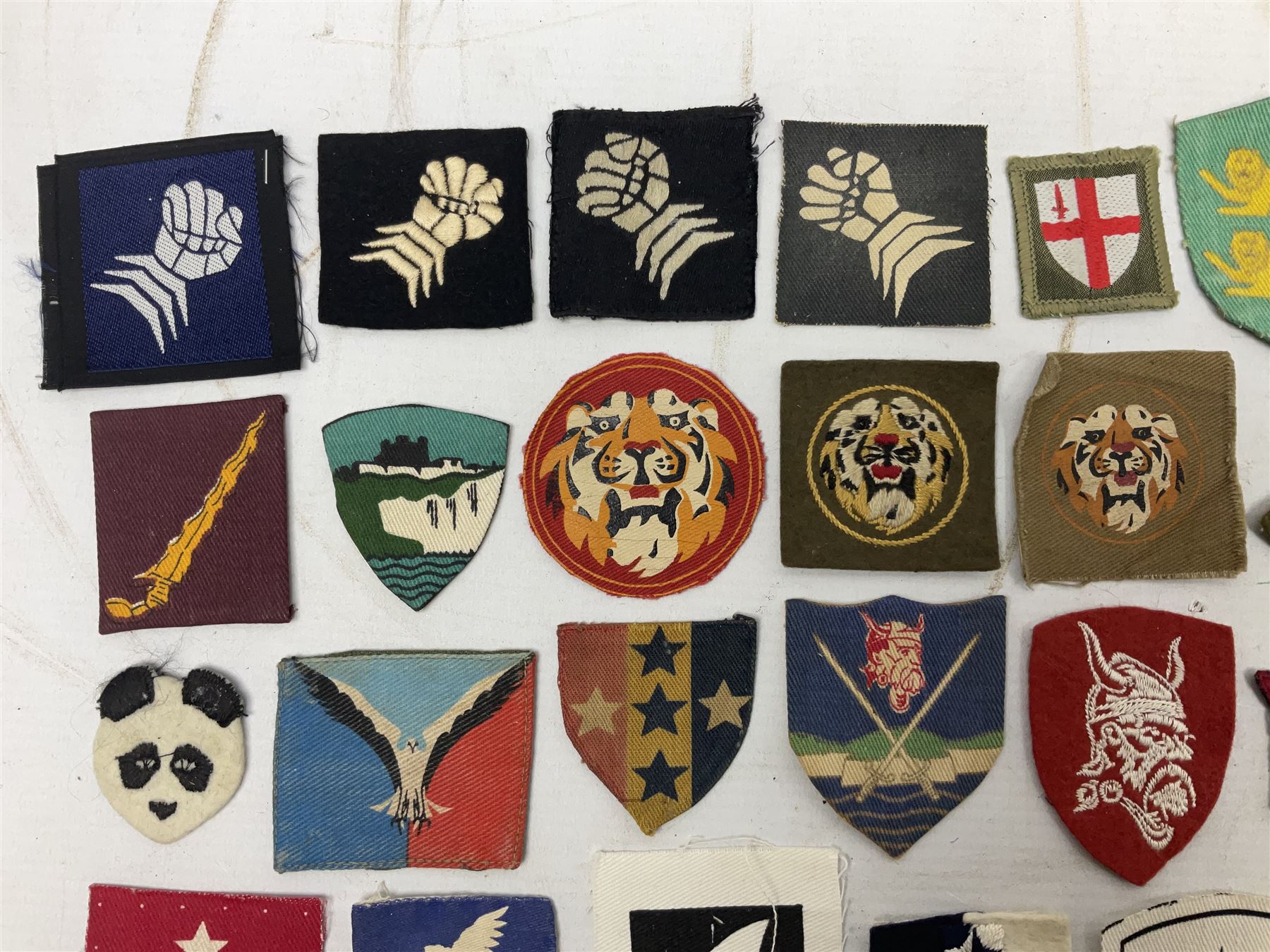 Approximately one-hundred printed and embroidered cloth badges including Royal Tank Regiment, Royal Armoured Corps, 219th Independent Infantry Brigade, Cyrenaica, Cyprus, Singapore and other districts, Gibraltar Garrison, East Anglian Brigade, 20th Armoured Brigade and various armoured divisions etc