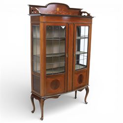 Edwardian mahogany display cabinet, arched back with satinwood and harewood marquetry foliate decoration above a moulded cornice, serpentine front fitted with twin glazed doors with astragal bars, the lower door panels inlaid with oval reserves, standing on elegant cabriole legs terminating in pad feet