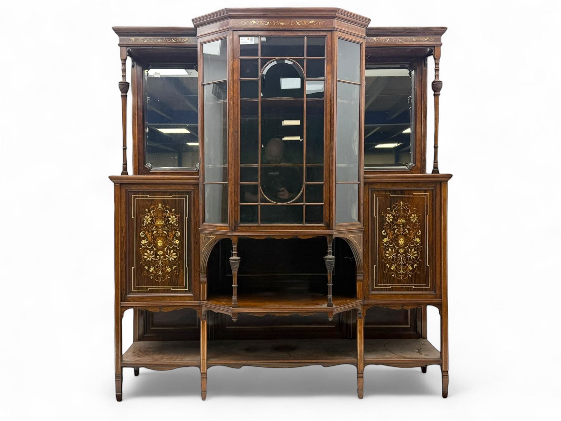 Victorian hardwood and inlaid display cabinet, central breakfront glazed display with astragal glazing and mirror back, flanked by mirrored alcoves with turned supports, below foliate and scrolling marquetry panels enclosing cupboard doors, shaped open shelves with turned supports beneath, on tapered and spade feet