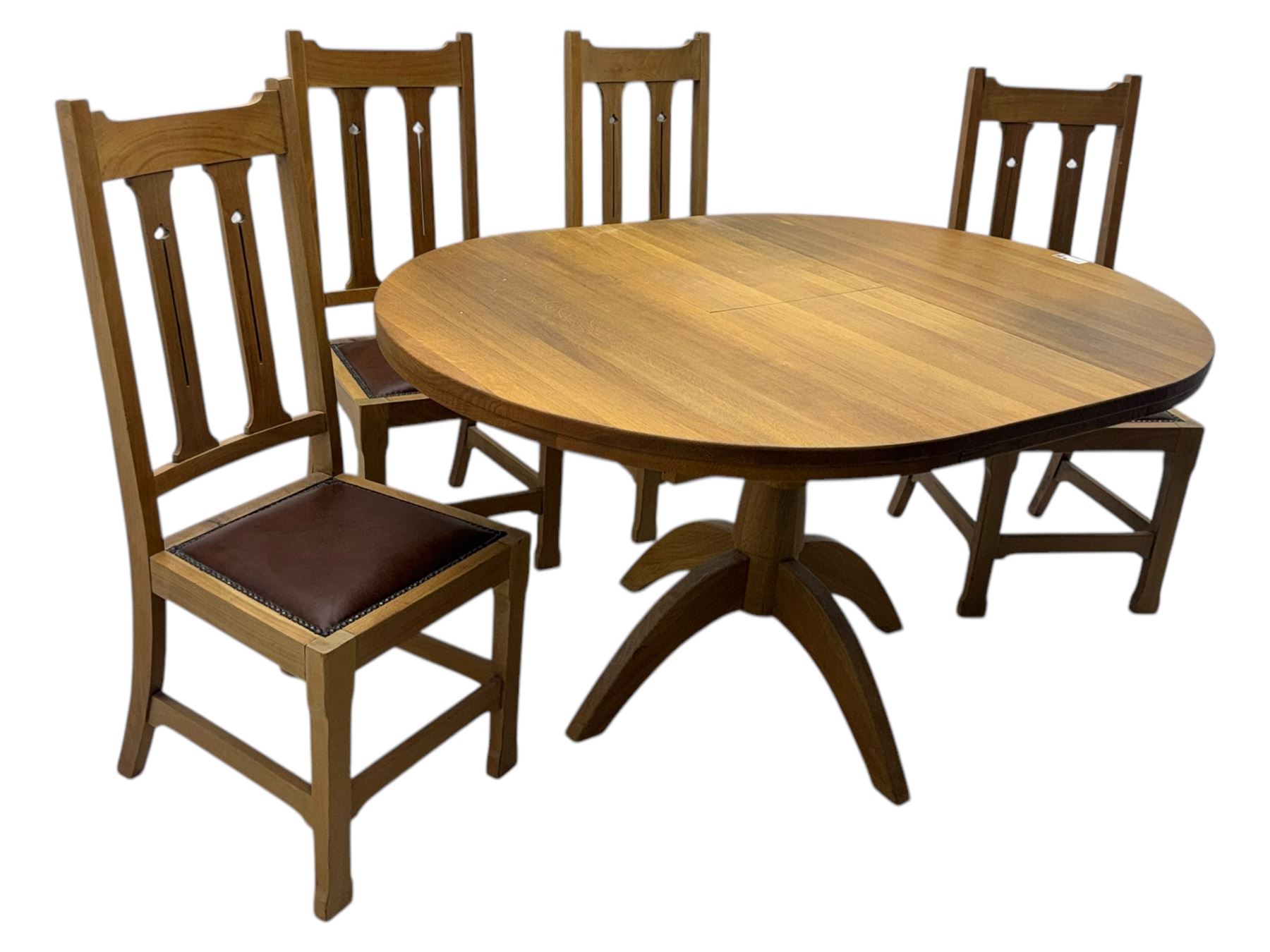 Contemporary light oak round extending dining table with four chairs, table has fold out leaf attached underneath on four out-swept legs, Oak chairs with straight top rail over twin slat back with pierced motifs, brown leather seat with brass studs, square legs joined by plain stretcher 