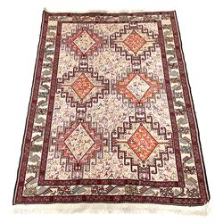 Pale ground rug, decorated with six medallions, multiple repeating stylised animal motifs, guarded boarder decorated with stylised flower heads
