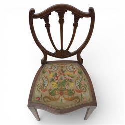 Edwardian pair of satinwood inlaid shield back chairs, the pierced shield shaped backs with central splats inlaid with floral and foliate motifs, tapestry upholstered serpentine seats, raised on square tapering supports