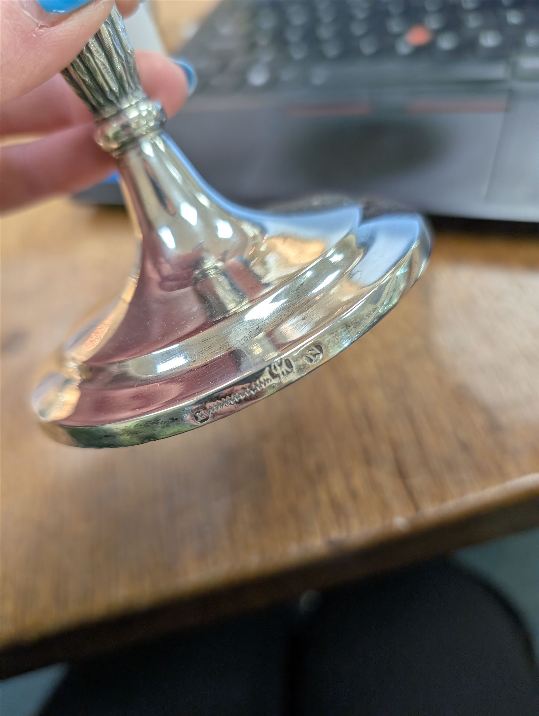 Pair of continental silver candlesticks, probably German Hanau, each of tapering form, with fern leaf decoration, upon a stepped circular base, with Hanau marks and assay scrape to base, H19cm