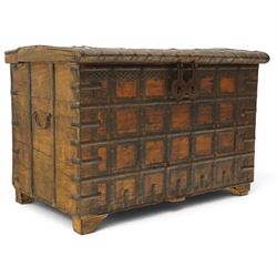 Large 19th century North Indian teak and wrought iron-bound dowry chest, probably Rajasthani, the shallow domed plank lid secured with broad iron straps above a lattice-carved frieze and grid of riveted iron bands, with twin shaped hasps, side carrying handles and fitted interior till, on bracket feet