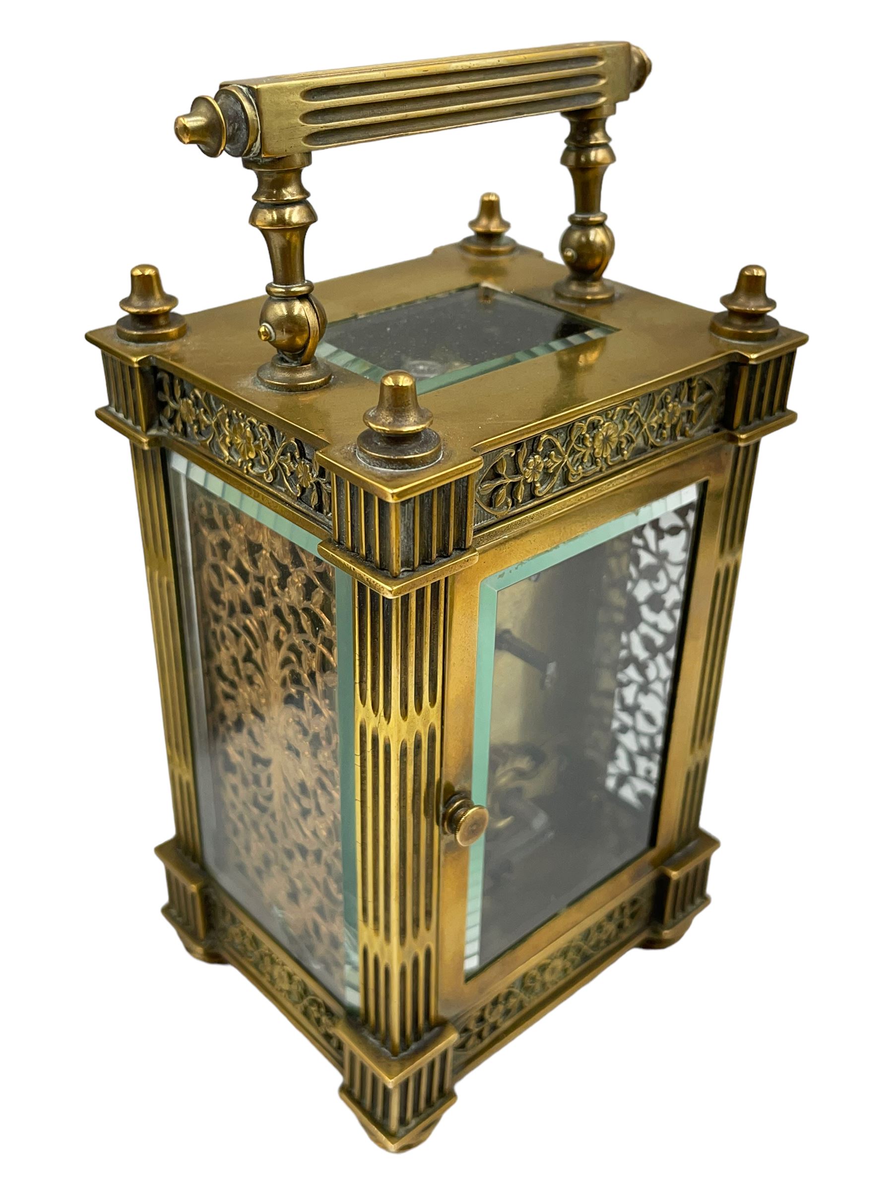 French - Matching pair of Edwardian 8-day timepiece carriage clocks with bevelled rectangular glass panels and overlaid friezes in gilt repousse work with fretted dial masks,  circular enamel chapter ring with Arabic numerals and steel spade hands, both clocks with single train movements, one movement with a jewelled cylinder platform escapement and the other with a jewelled and silvered lever platform escapement.
No Keys.